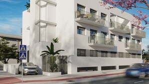 A modern multi-story building with balconies, a pedestrian crossing sign, and a car parked in front.