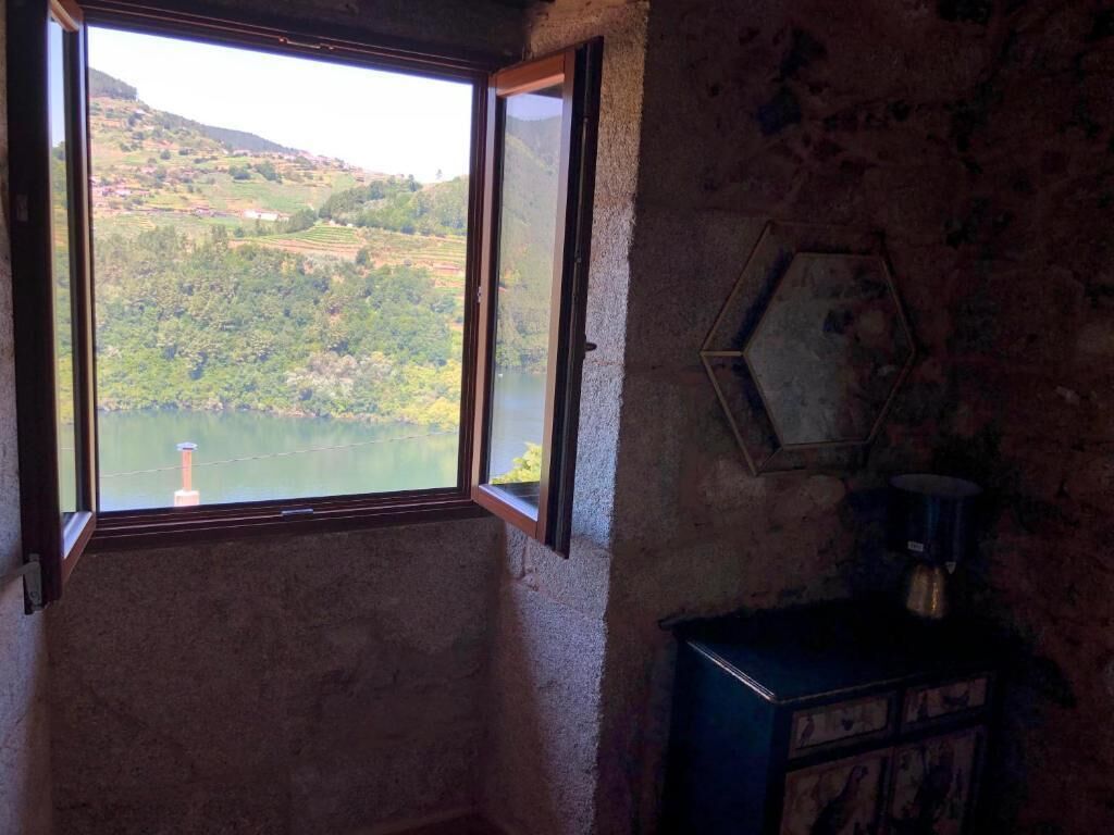 Une pièce dotée d’une grande fenêtre donnant sur un lac et des collines.