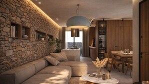 Een moderne woonkamer met een stenen muur, een hoekbank, een ronde salontafel en een eethoek met houten meubels.