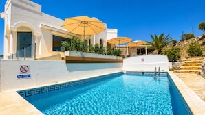 Une piscine avec un panneau indiquant qu’il est interdit de plonger, une chaise de maître-nageur et un panneau indiquant qu’il est interdit de se baigner.