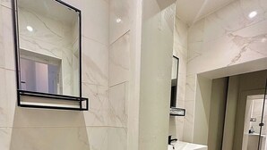 A modern bathroom with a toilet, sink, and mirror. - Ground-floor Flat 1 Min to Tube (London)
