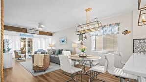 A modern living room with a sofa, chairs, a dining table, and a chandelier. - 10% off 3-7 nights thru Dec. 2BR 2BA on waterway in gated comm. NMB. Pool. (North Myrtle Beach)