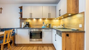 Eine moderne Küche mit weißen Schränken, einem eingebauten Ofen und einer Holz Arbeitsplatte.