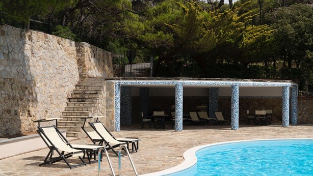A swimming pool with lounge chairs and a covered seating area. - Sea view holiday home, surrounded by Mediterranean scrub with swimming pool (Chioma)