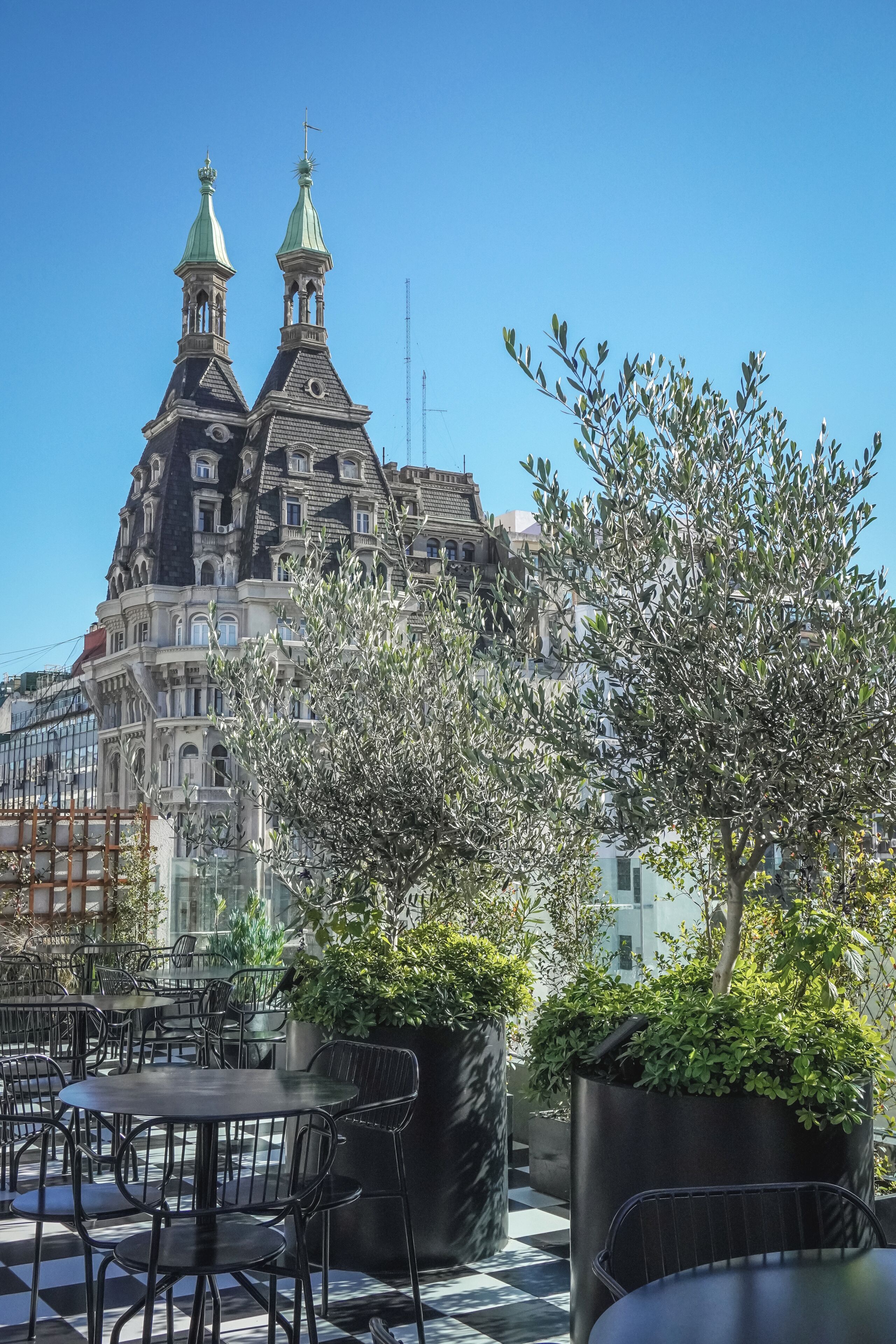A terrace with outdoor seating and a view of a historic building with ornate architecture.