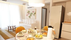 A modern dining area with a round table, yellow chairs, and a white ceiling light. - Aira Apart Hotel Boutique (Buenos Aires)