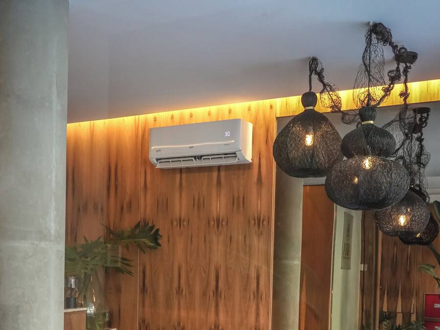 A modern interior with a round bean bag chair, a small round table, and a wall-mounted air conditioner.