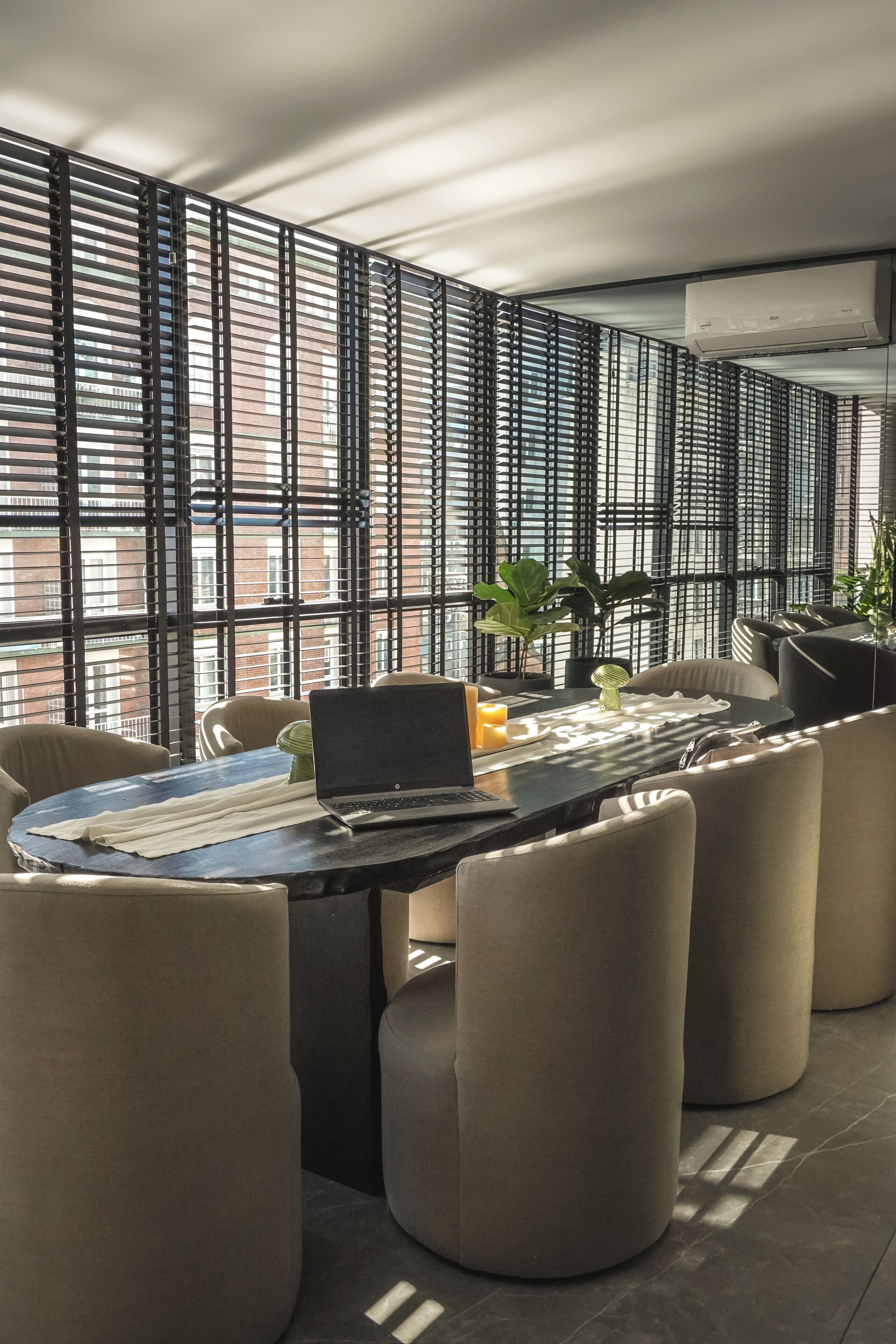 Una sala de conferencias moderna con una larga mesa, sillas cómodas y vistas a través de una ventana con diseño.
