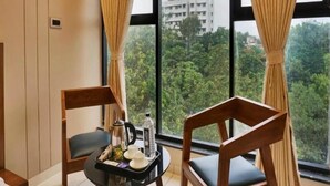 A room with two wooden chairs, a small table with a tray, and a window with curtains. - HOTEL SAYBA INTERNATIONAL (Pune)