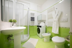 A bathroom with a shower, sink, toilet, and bidet. - Studio Cala di Sole (Imperia)