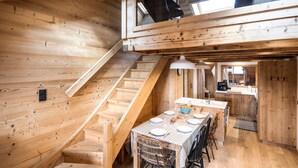 A wooden interior with a dining area, staircase, and kitchen. - Holiday Home “L'alpin” with Mountain View (Les Déserts)