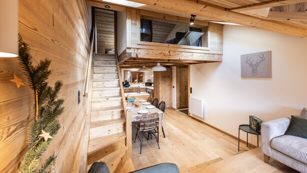 A wooden interior with a dining area, staircase, and a loft space. - Holiday Home “L'alpin” with Mountain View (Les Déserts)