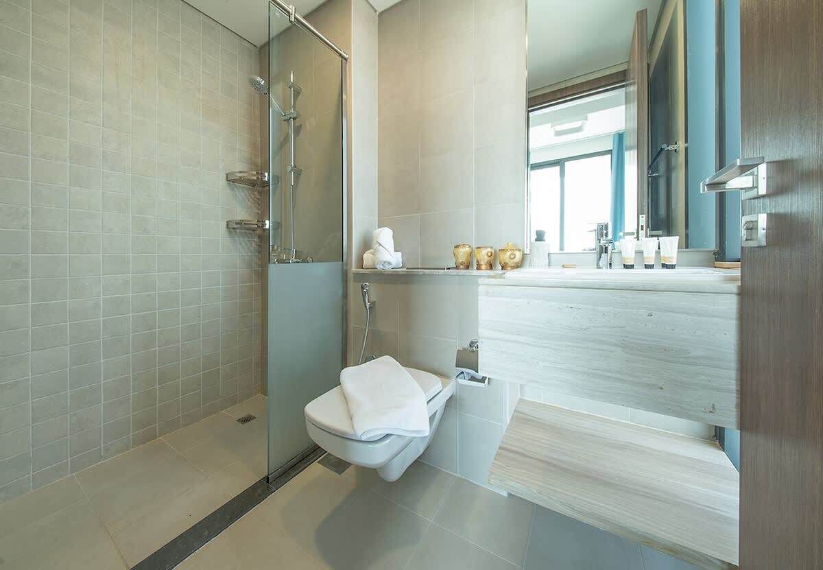 Une salle de bain moderne avec une douche à parois de verre, des toilettes et un meuble-lavabo avec un miroir.