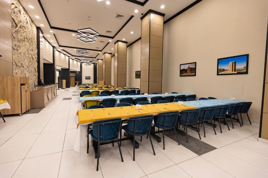 A conference room with multiple tables and chairs, a reception area, and a stone accent wall.