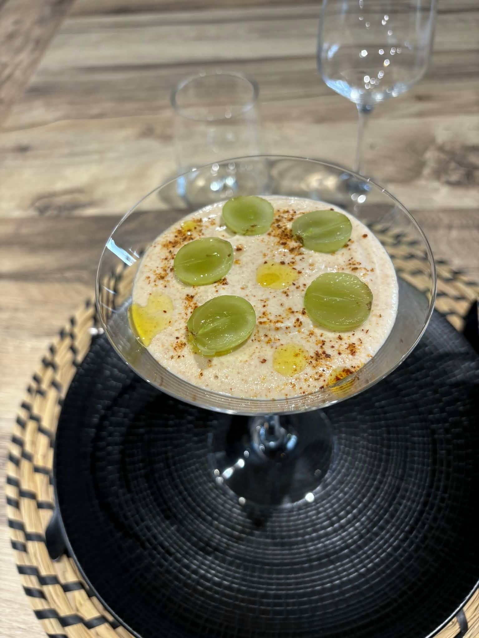 Un postre en un vaso sobre un posavasos negro.