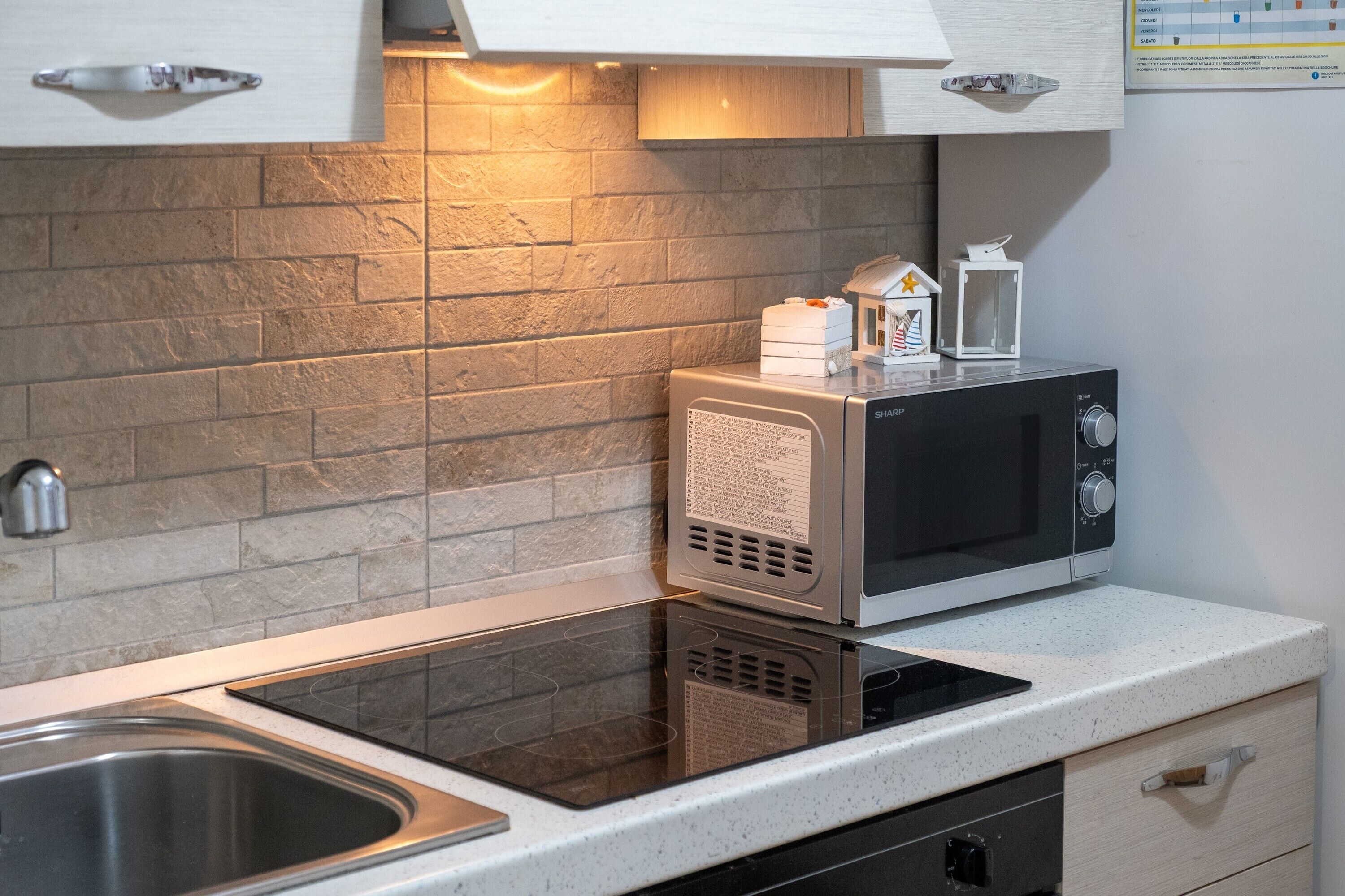 Een koelkast, een oven, een kookplaat, kookgerei, borden en bestek