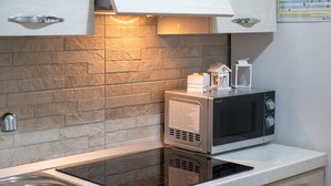 A kitchen with a stainless steel sink, a microwave, and a built-in oven. - Rossini 14 | Downtown and Beach Within Walking Distance (Porto Cesareo)