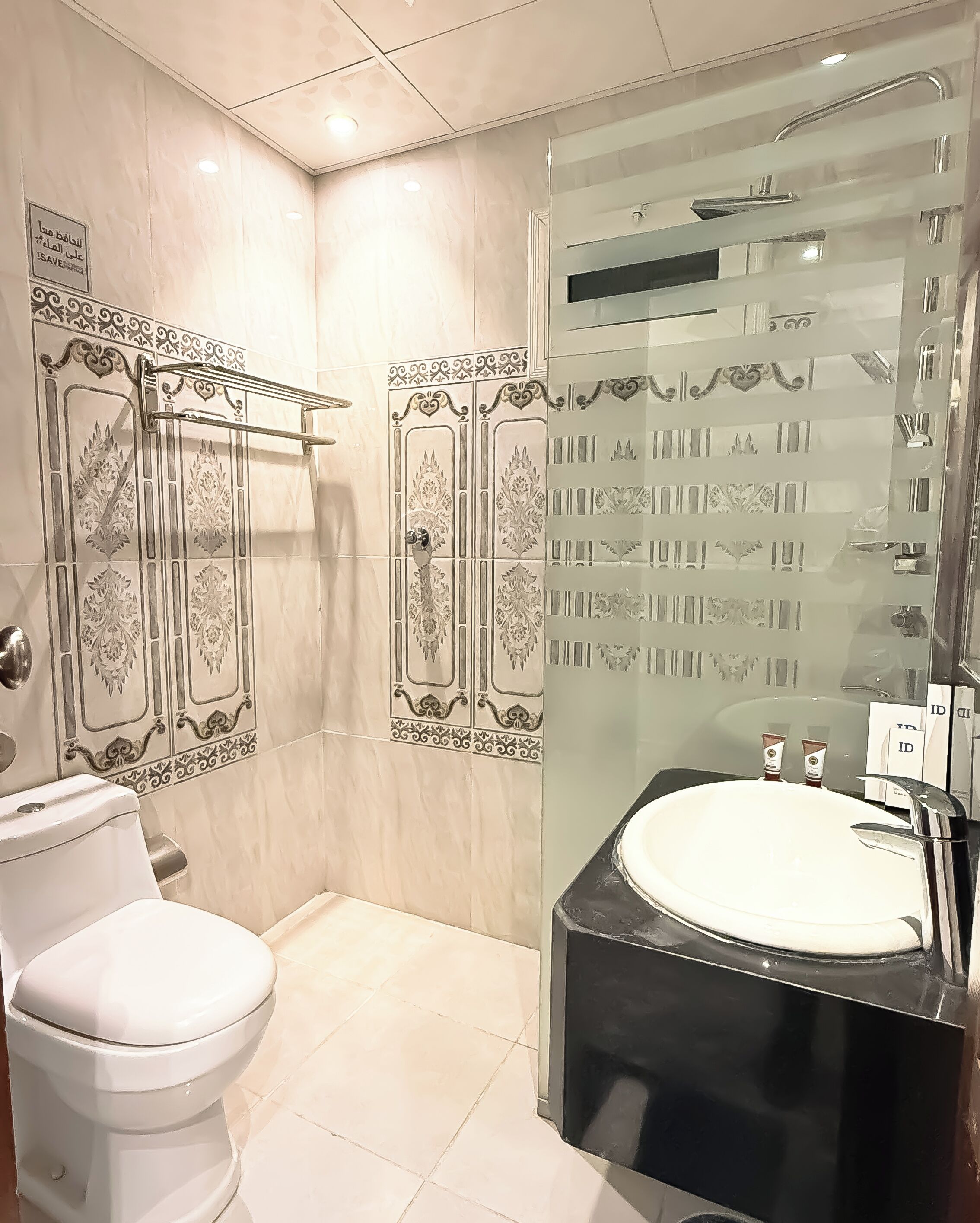 Une salle de bain moderne avec des toilettes, une douche à parois de verre et un lavabo noir.