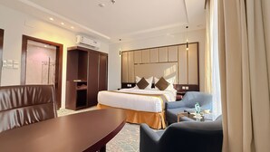 Une chambre d’hôtel comprenant un lit, un bureau, une chaise, une armoire et une salle de bain.