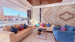 Un salon moderne avec deux canapés, une table basse et une vue sur l’extérieur.
