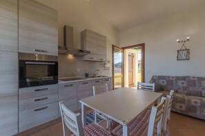 Una cucina moderna con zona pranzo, divano e vista sull'esterno.