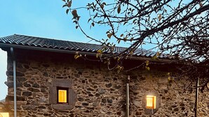 Un edificio de piedra con dos ventanas pequeñas y una puerta.
