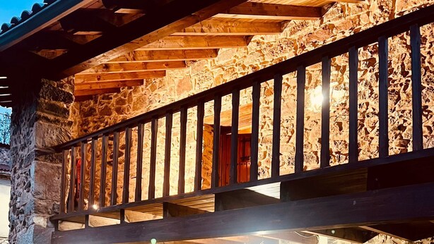 Un edificio de piedra con un balcón de madera y una puerta marcada con el número 1.