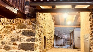 Una escalera de piedra que conduce a una puerta de madera, con una reja metálica y un tejado de baldosas arriba.
