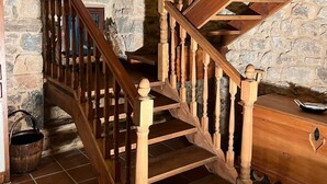 Una escalera de madera con un muro de piedra y un interior rústico.