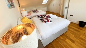 Une chambre à coucher avec un lit, des oreillers, une lampe de chevet et une fenêtre.