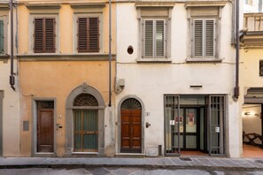 A building with a ground-floor entrance, a second-floor window with shutters, and a third-floor window with shutters. - San Lorenzo Mezzanine (FIRENZE)