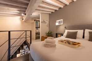 Ein Schlafzimmer mit Bett, Nachttisch und Blick auf eine Treppe.
