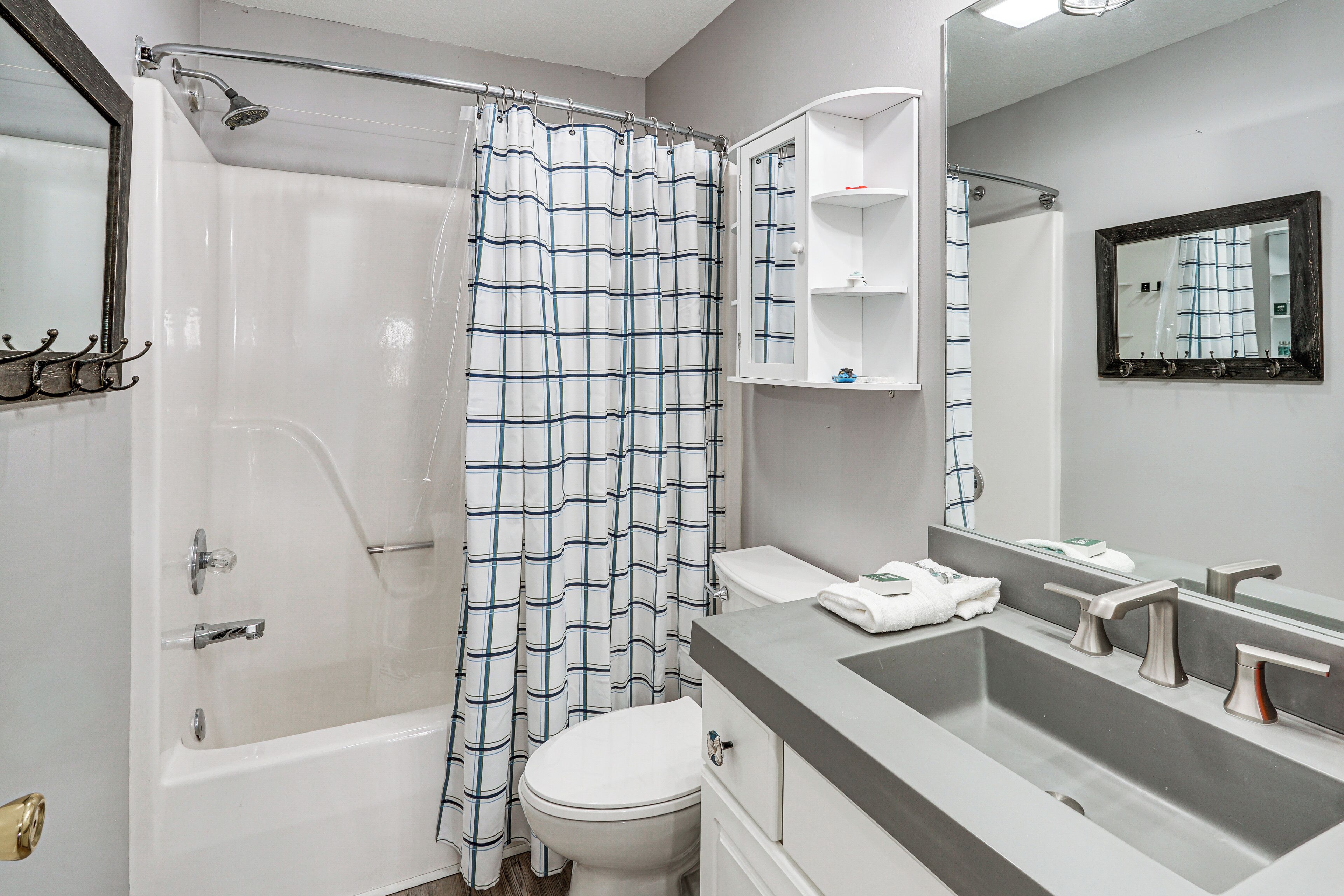 Een badkamer met douche, toilet en wastafel.