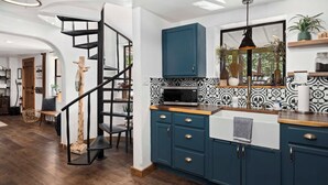 Una cucina moderna con un armadietto blu, un forno a microonde e una finestra con piante.