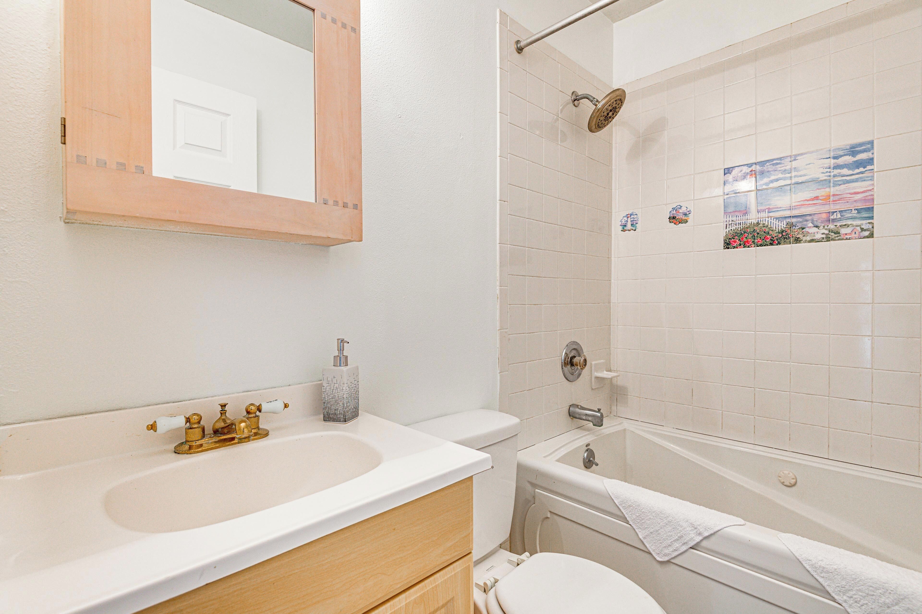 A bathroom with a white sink, toilet, and bathtub.