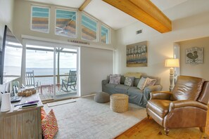 A living room with a leather armchair, a sofa, and a dining area with a table and chairs. - Dock + Fire Pit: Tranquil Home on Lake Livingston (Livingston)