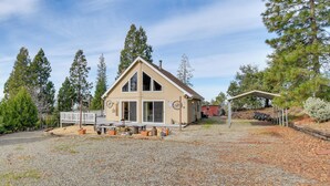 A two-story building with a sloped roof, a covered patio, and a gravel driveway. - Deck & Wooded Views: 5-acre Auberry Retreat! (Auberry)