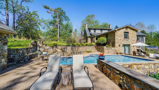 A stone house with a pool, lounge chairs, and a stone wall. - Aldie Home w/ Private Pool: Near Wineries! (Aldie)