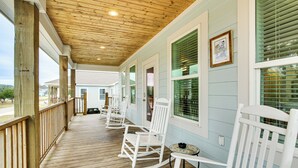 A covered porch with wooden railings and white rocking chairs. - Steps to Sand! Family-friendly Long Beach Escape (Long Beach)