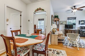 A dining area with a wooden table, chairs, and a decorative mirror. - Work From Home: Peaceful Conroe Escape w/ Patio! (Conroe)