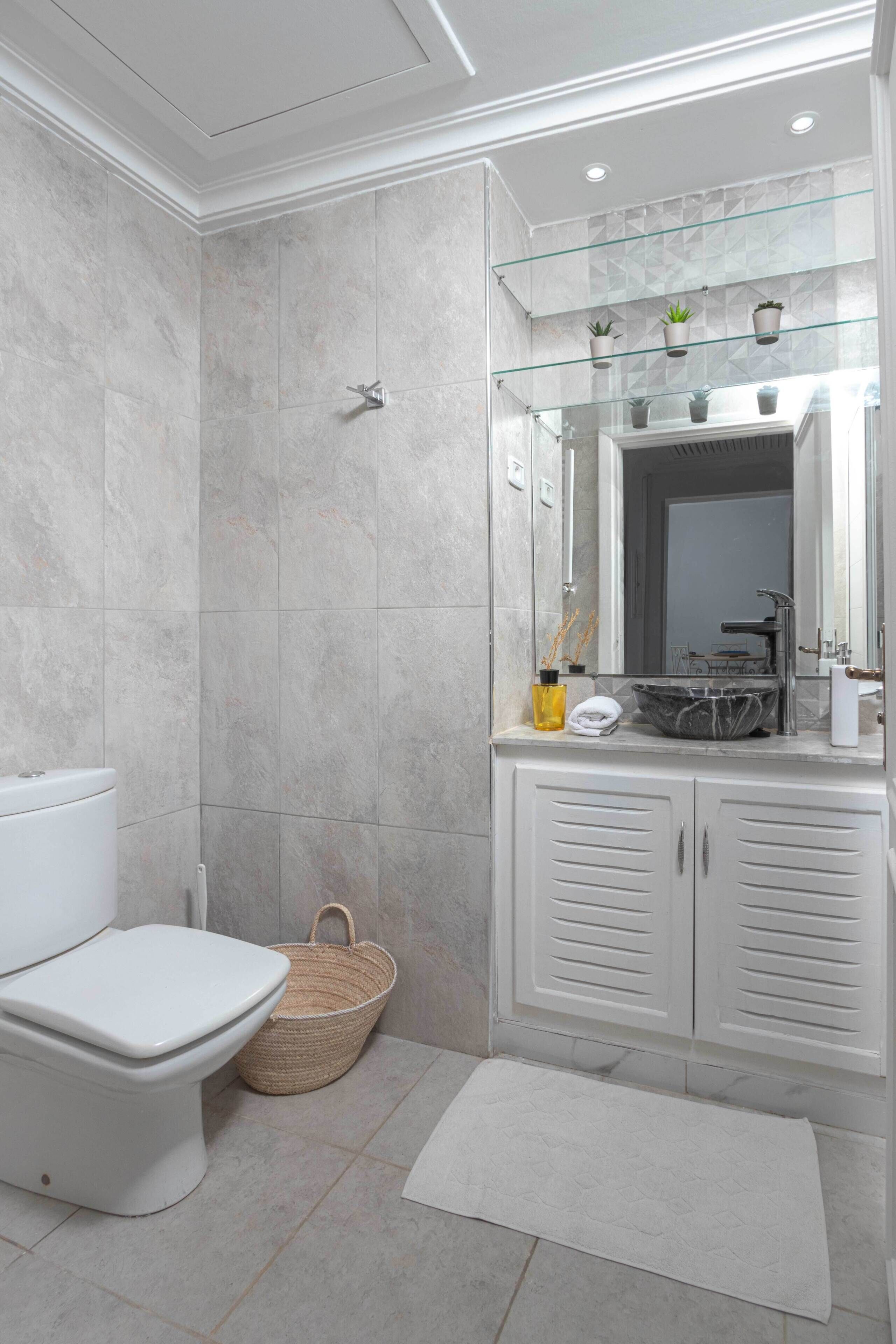 A modern bathroom with a toilet, bidet, and glass shower enclosure.
