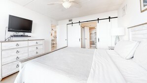 A bedroom with a bed, a dresser, a TV, and a ceiling fan. - 2BR w/ Gulf-view Balcony: Suntide III - Unit 307 (South Padre Island)