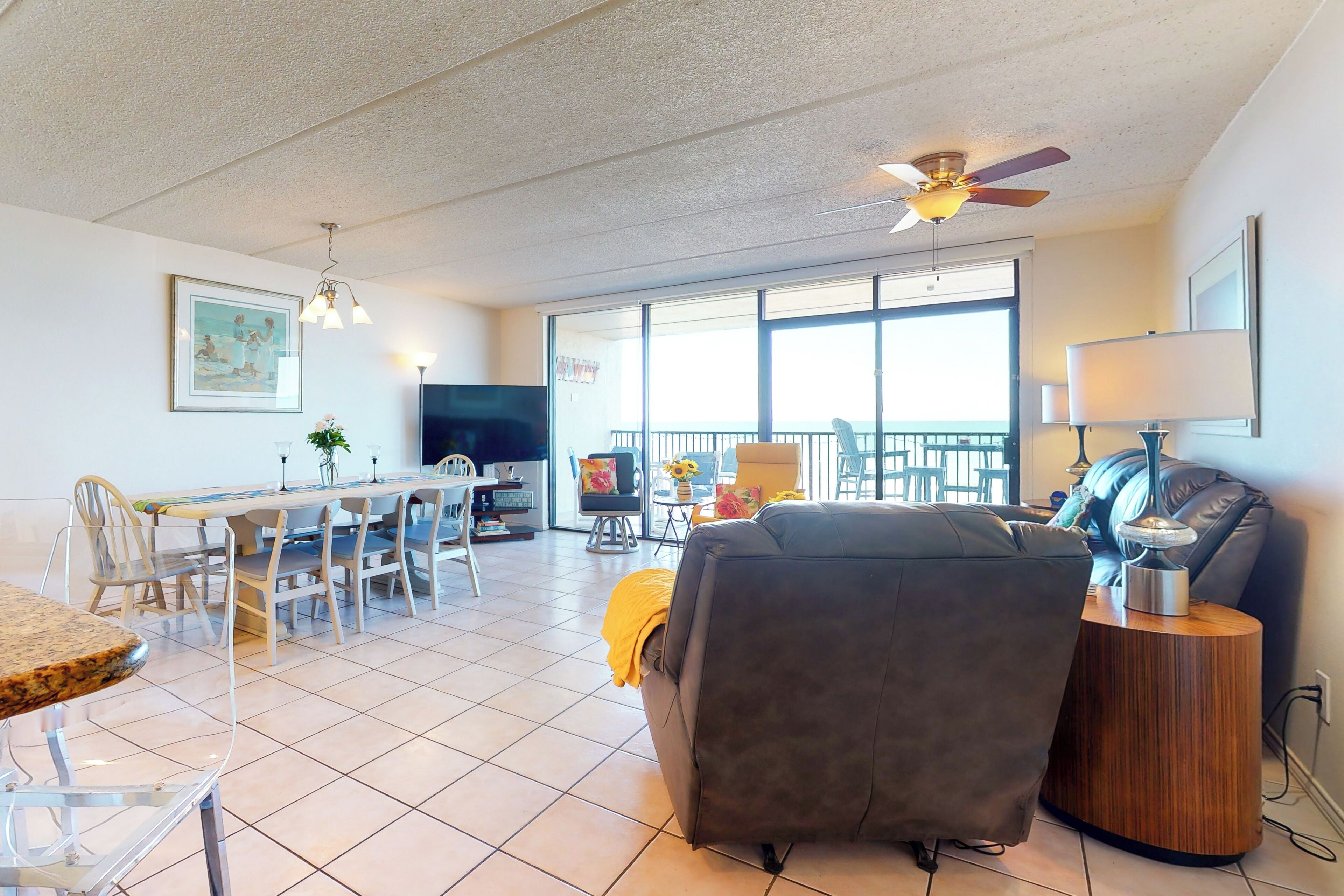 A spacious living area with a dining table, chairs, a sofa, and a TV.