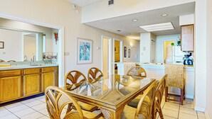 Una cocina amplia con gabinetes de madera, una mesa de comedor con sillas y un refrigerador.