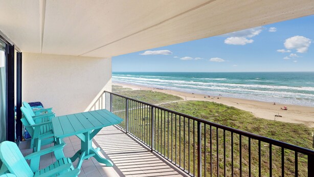 Un balcon avec vue sur la plage et l’océan.