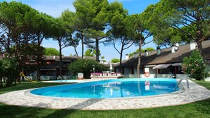 A swimming pool surrounded by grass and trees, with a no swimming sign visible. - Cozy Apartment With Swimming Pool Access (San Michele al Tagliamento)