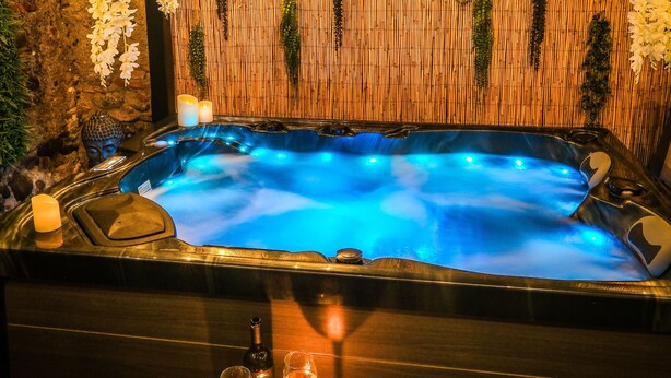 A hot tub with a bamboo backdrop and candles. - La Villa Lova - Loveroom with private spa in Pamiers (Pamiers)