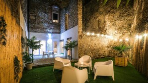 A courtyard with artificial grass, white chairs, and potted plants. - La Villa Lova - Loveroom with private spa in Pamiers (Pamiers)