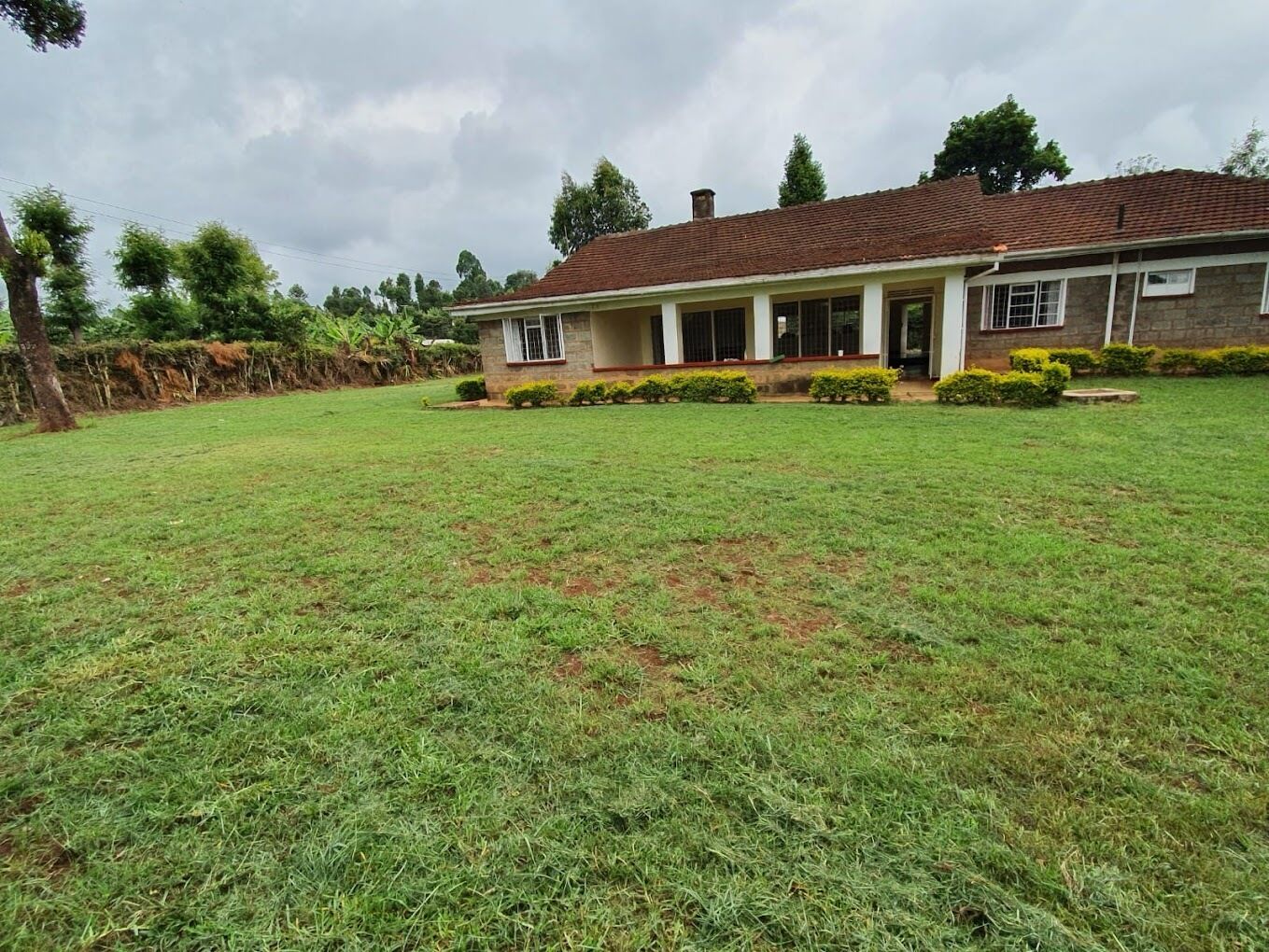 A two-story house with a covered porch, a well-maintained lawn, and a brick exterior.