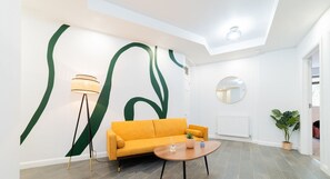 Spacious living room featuring a double sofa bed, modern décor and a comfortable seating area. Bright open layout ideal for relaxing or unwinding during your stay. - 10% OFF 2BR Near Victoria Line • Perfect Location (London)